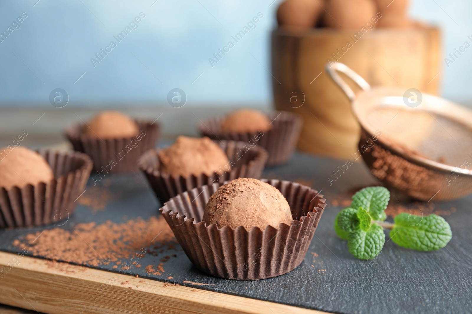 Photo of Tasty chocolate truffles on board, closeup view