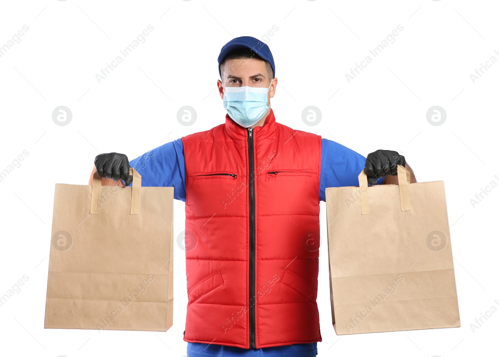 Photo of Courier in medical mask holding paper bags with takeaway food on white background. Delivery service during quarantine due to Covid-19 outbreak