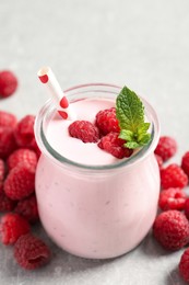 Image of Yummy raspberry smoothie in jar and fresh berries on table