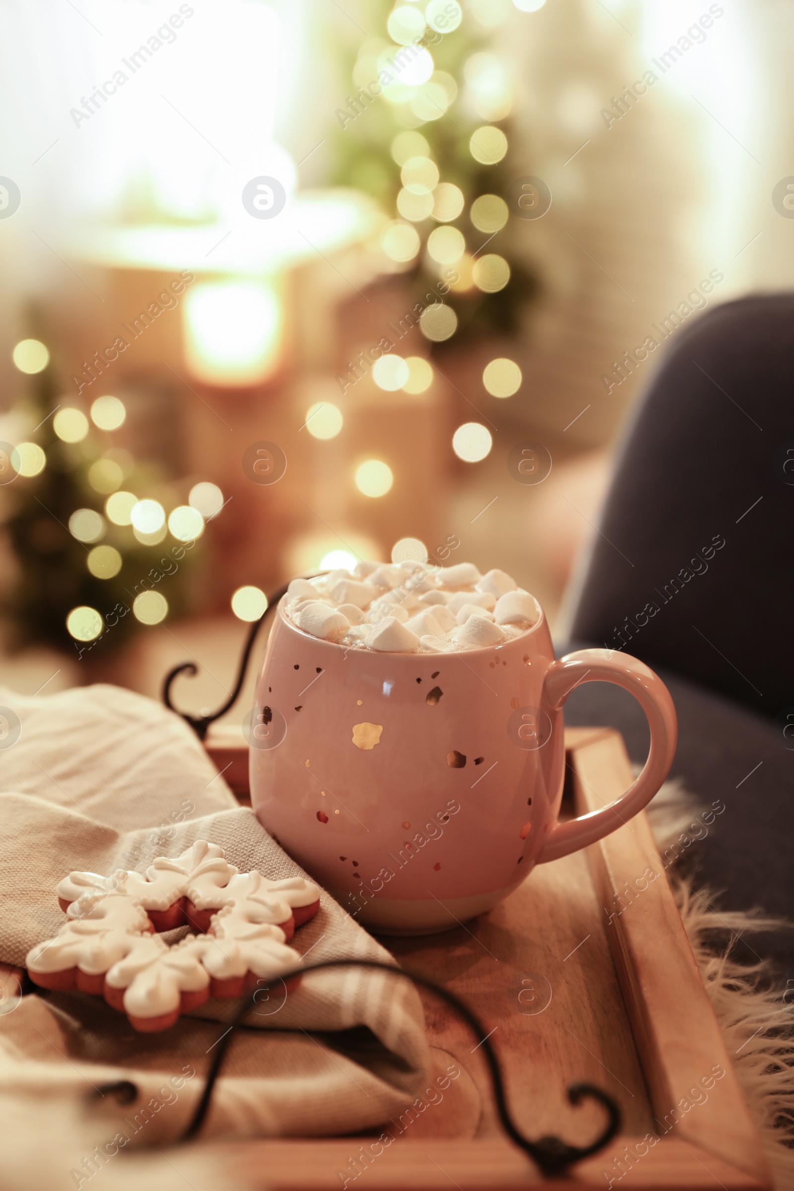 Photo of Cup of hot drink with marshmallows and cookie on wooden tray indoors. Christmas atmosphere