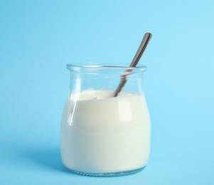 Tasty organic yogurt on light blue background