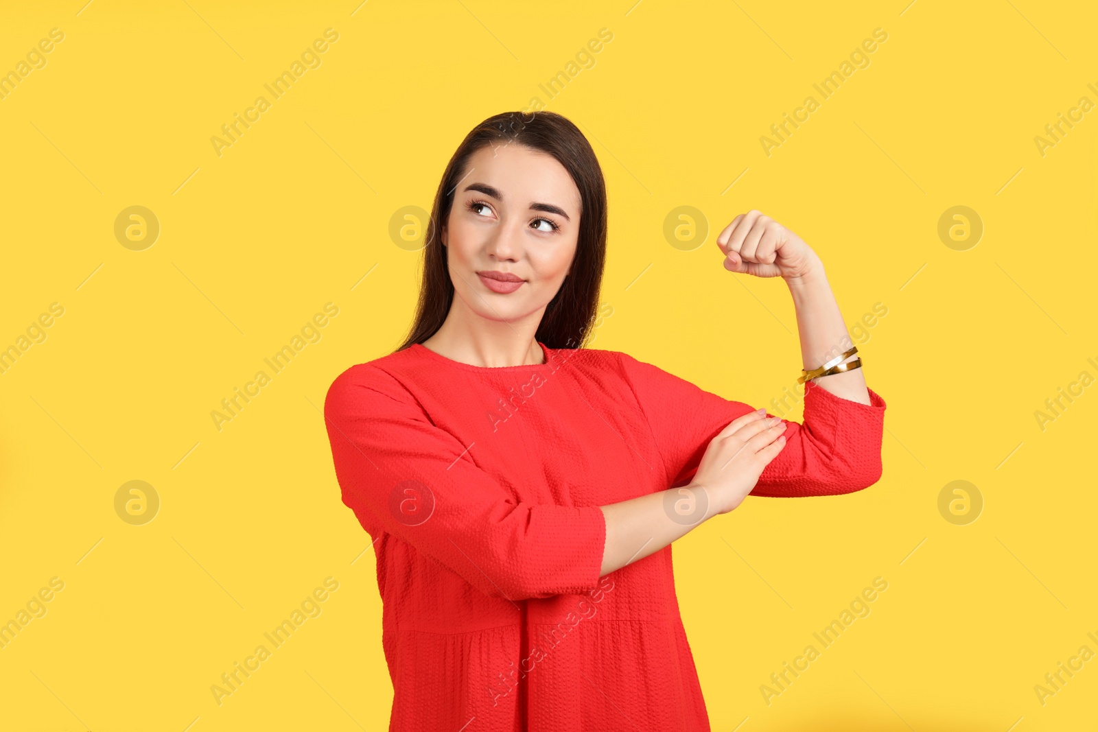 Photo of Emotional strong woman as symbol of girl power on yellow background. 8 March concept