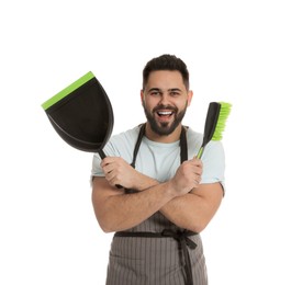 Young man with brush and dustpan on white background