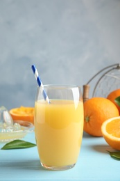 Glass with orange juice and fresh fruit on table