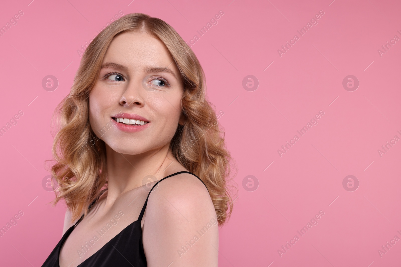 Photo of Portrait of beautiful woman with blonde hair on pink background. Space for text