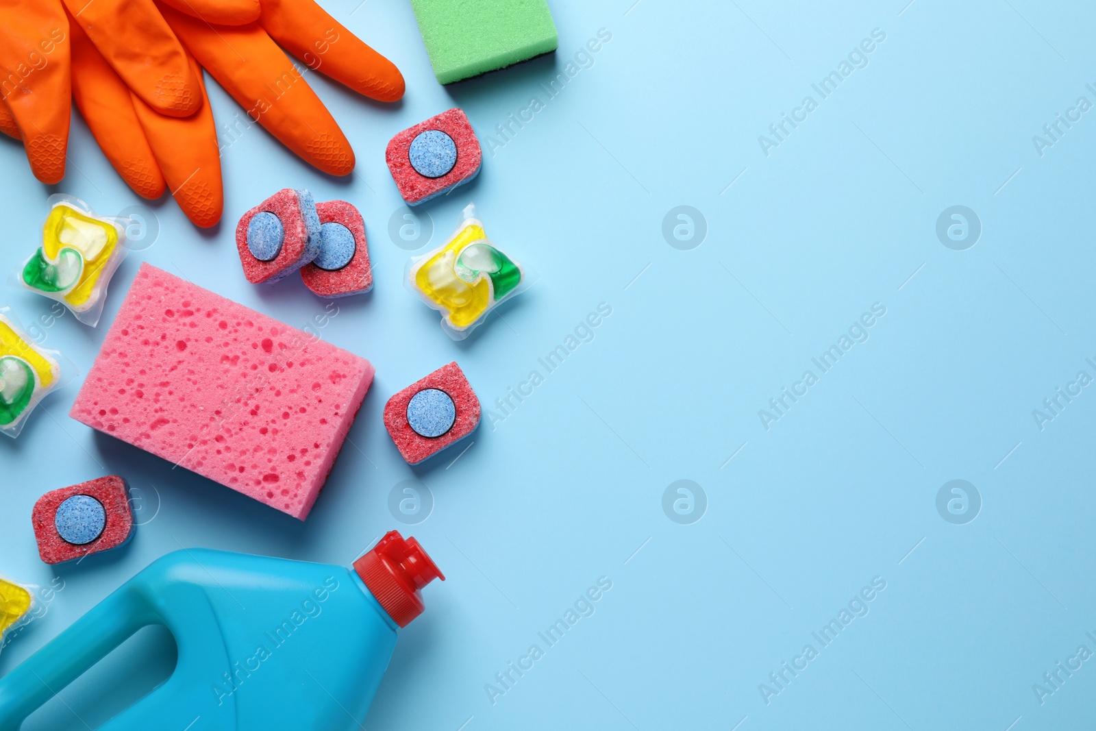 Photo of Flat lay composition with dishwasher detergent pods and tablets on light blue background, space for text