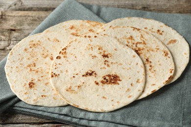 Photo of Many tasty homemade tortillas on wooden table