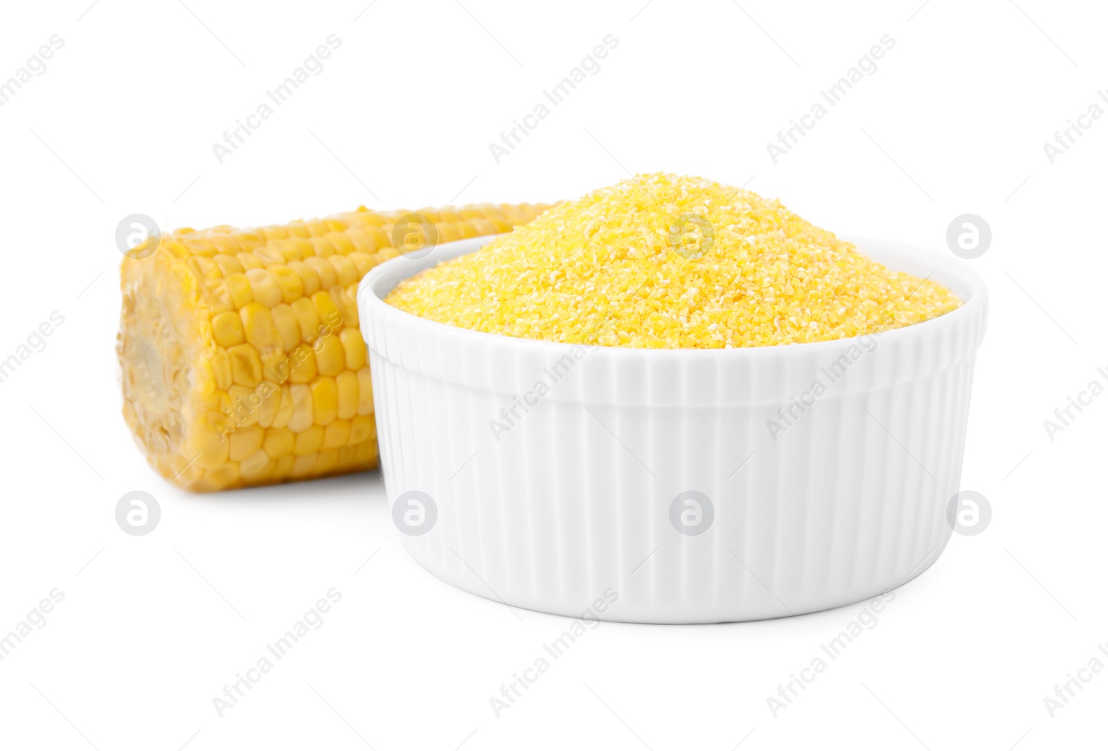 Photo of Raw cornmeal in bowl and corn cob isolated on white