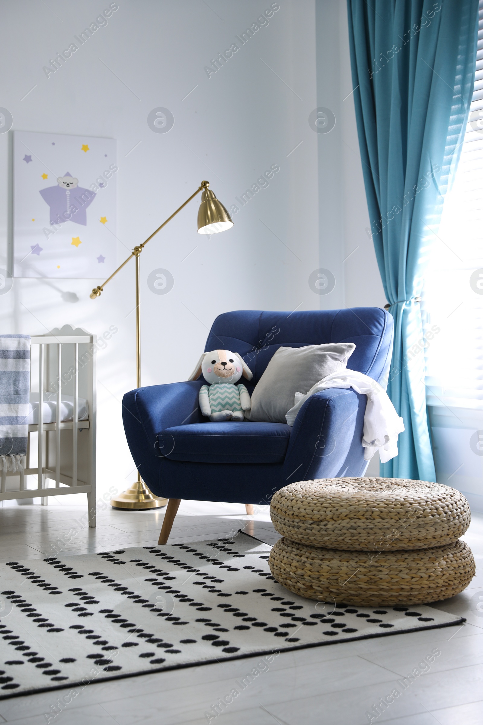 Photo of Cozy baby room interior with comfortable armchair