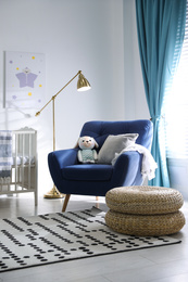 Cozy baby room interior with comfortable armchair
