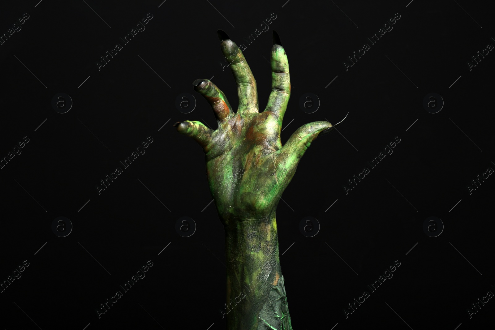 Photo of Scary monster on black background, closeup of hand. Halloween character