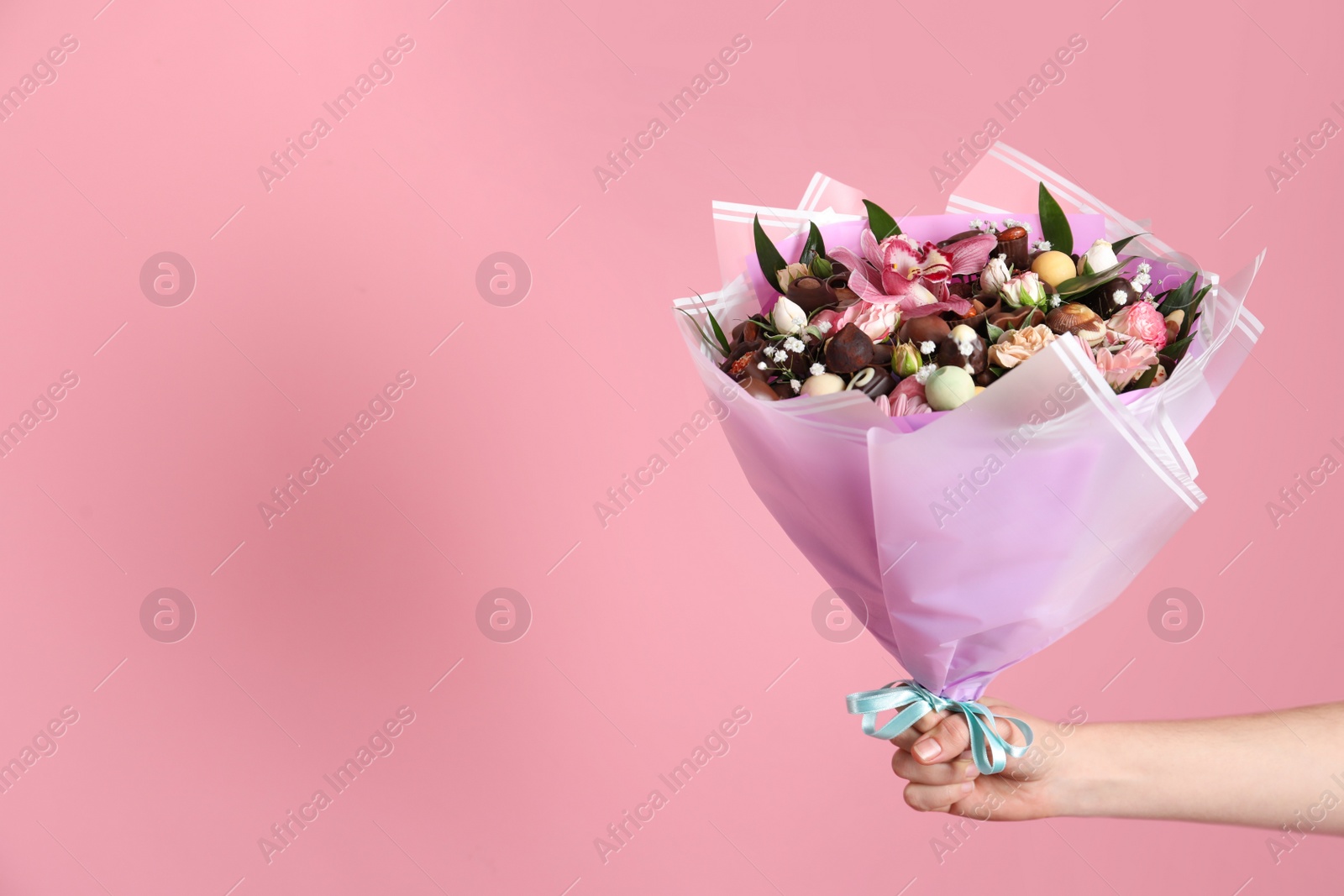 Photo of Woman with beautiful edible bouquet on pink background, closeup. Space for text