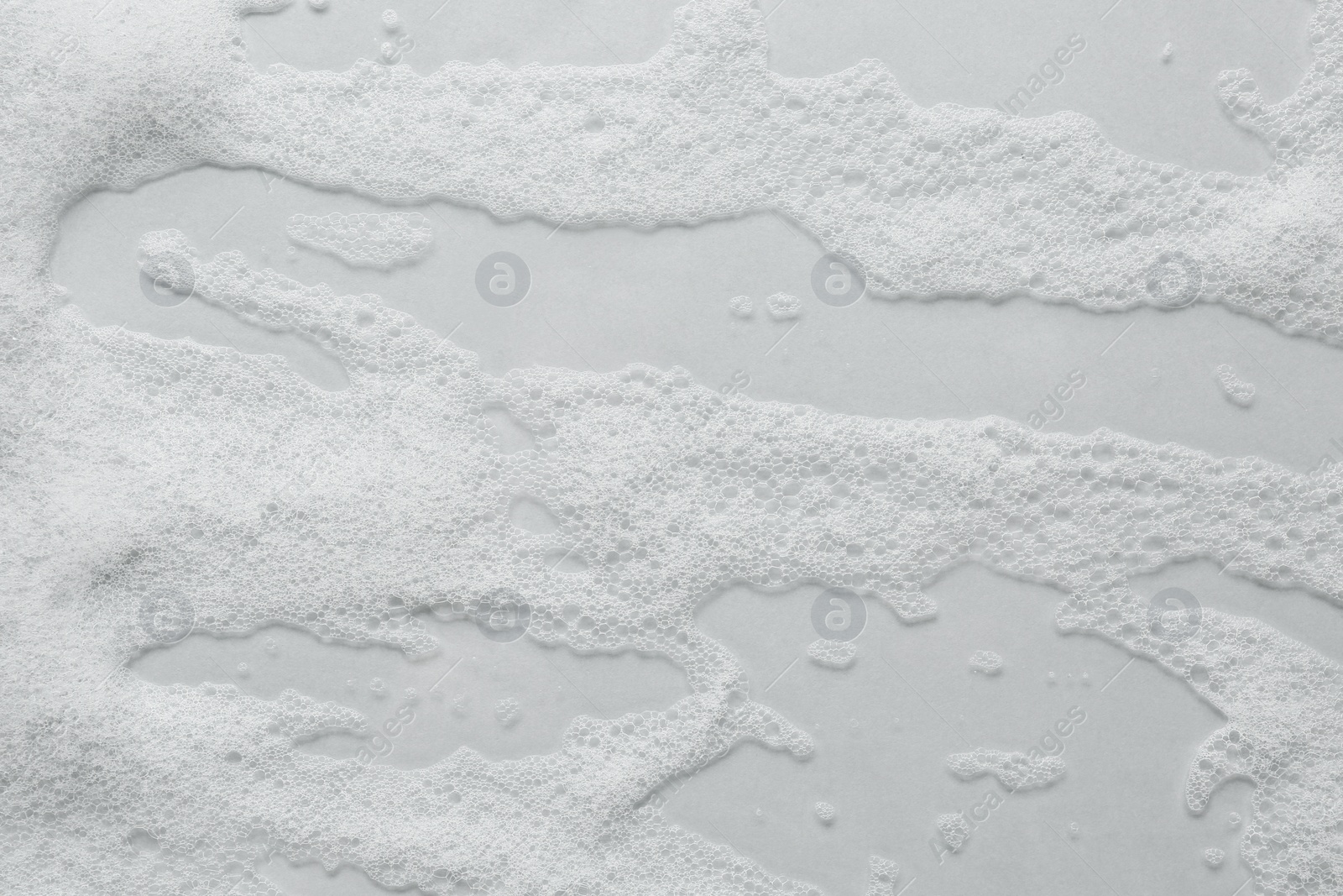 Photo of Fluffy bath foam on light background, top view