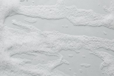 Photo of Fluffy bath foam on light background, top view