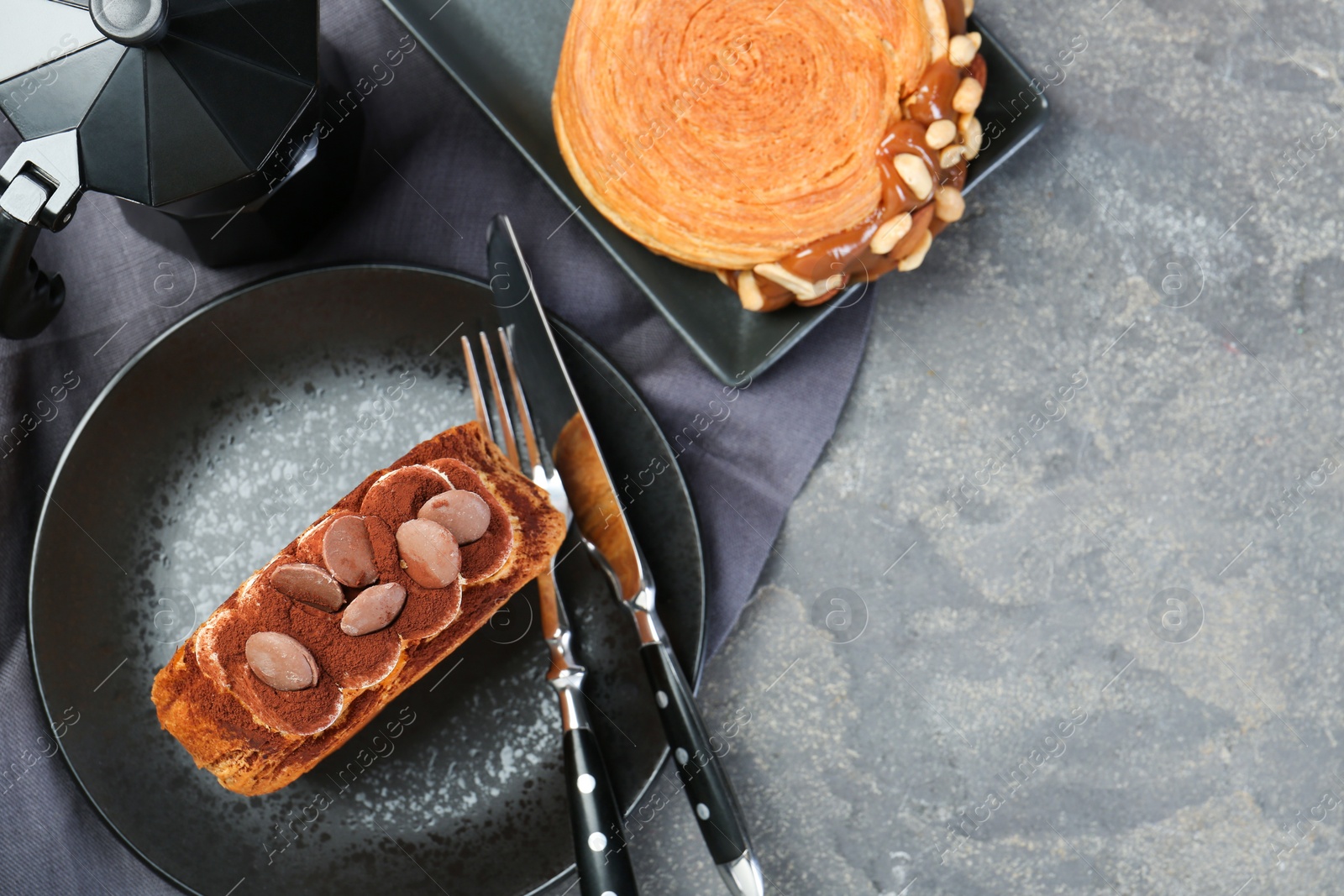 Photo of Round croissants served on grey table, flat lay. Tasty puff pastry