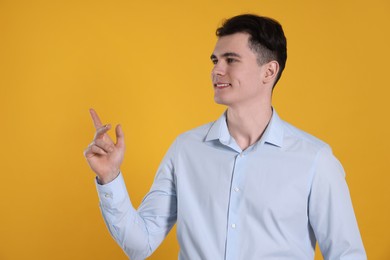 Photo of Portrait of handsome young man gesturing on yellow background