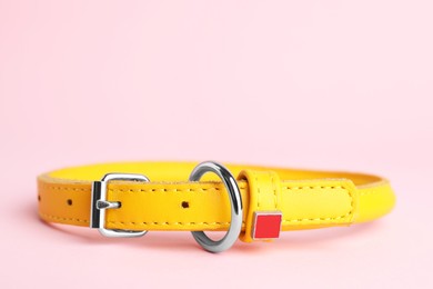 Photo of Yellow leather dog collar on pink background, closeup. Space for text