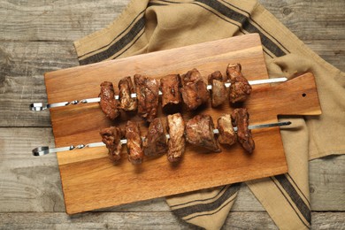 Delicious shish kebabs on wooden table, top view