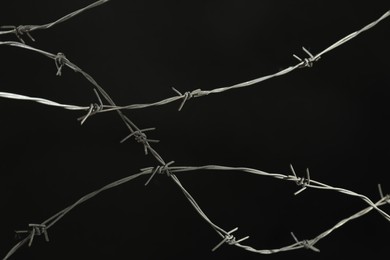 Photo of Shiny metal barbed wire on black background