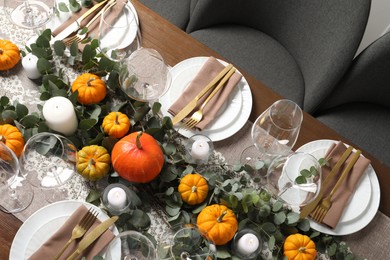 Beautiful autumn table setting. Plates, cutlery, glasses, pumpkins and floral decor, above view