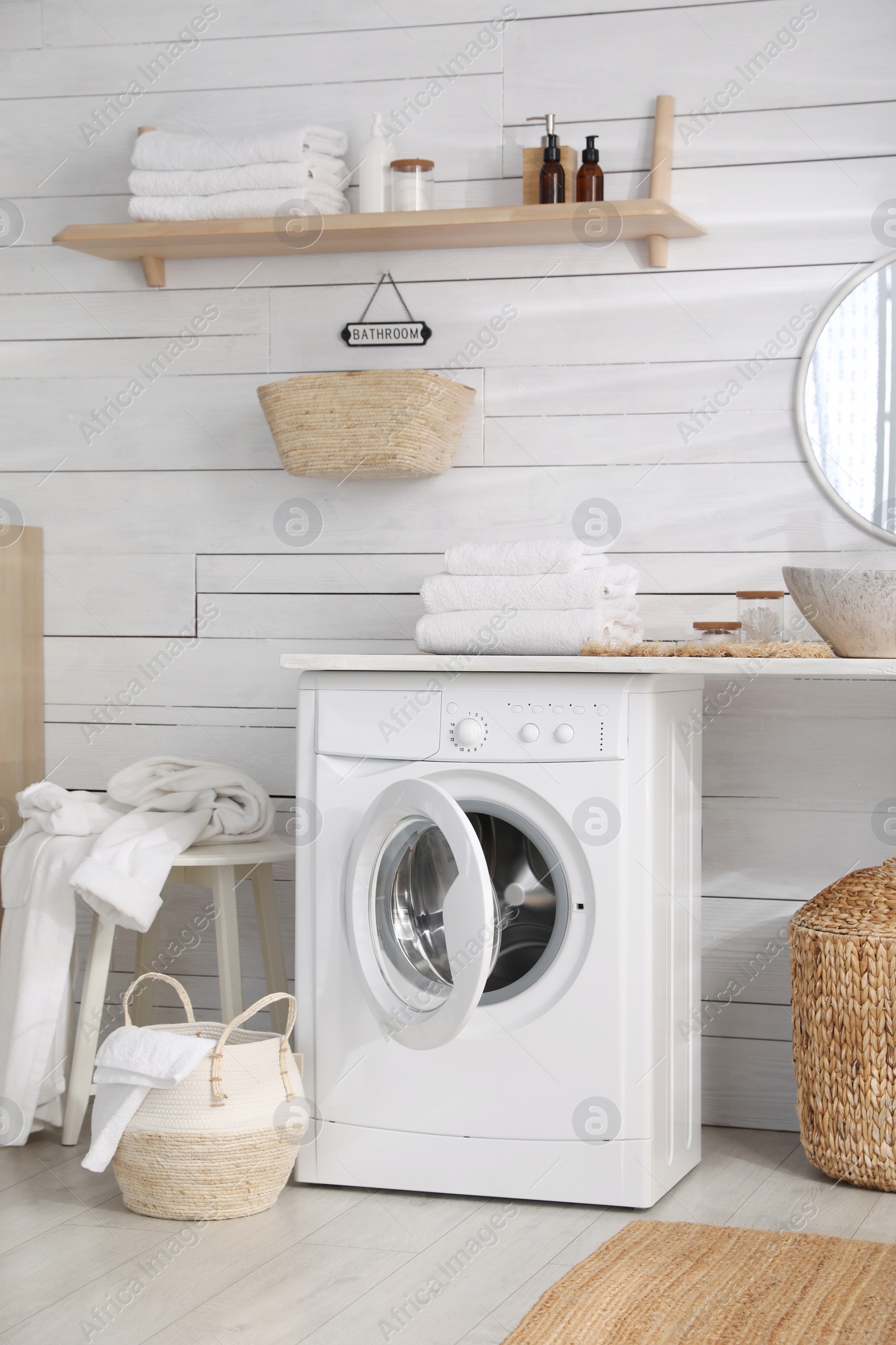 Photo of Stylish bathroom interior with modern washing machine