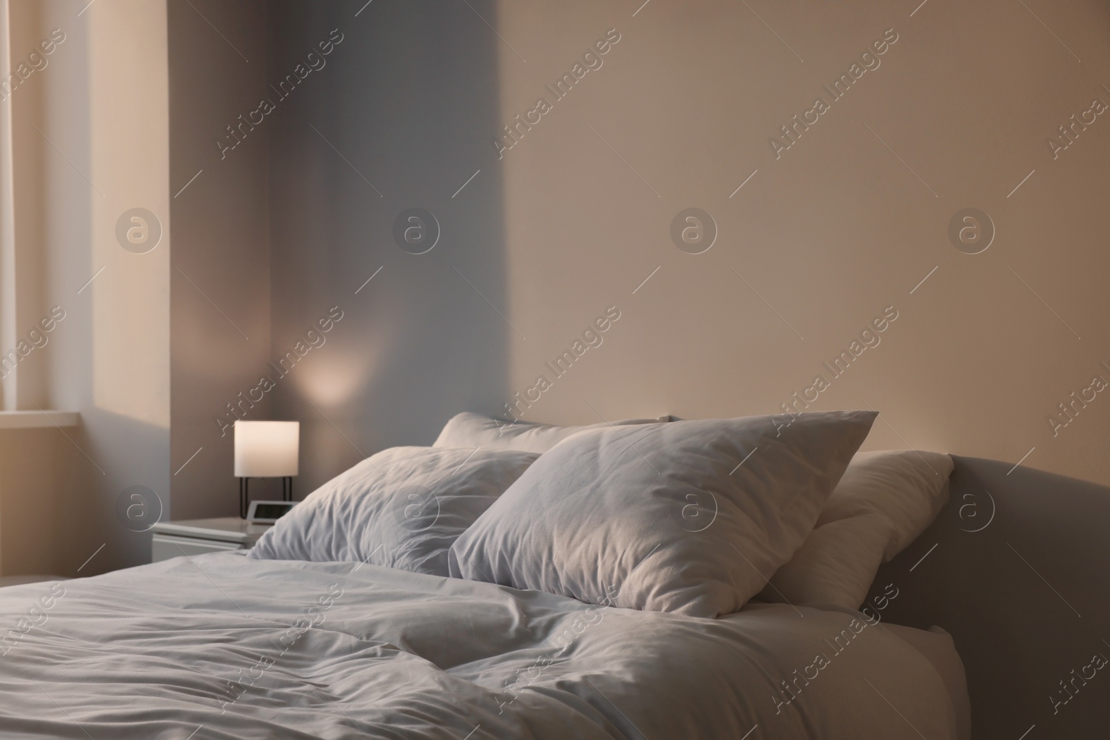 Photo of White soft pillows on bed in room