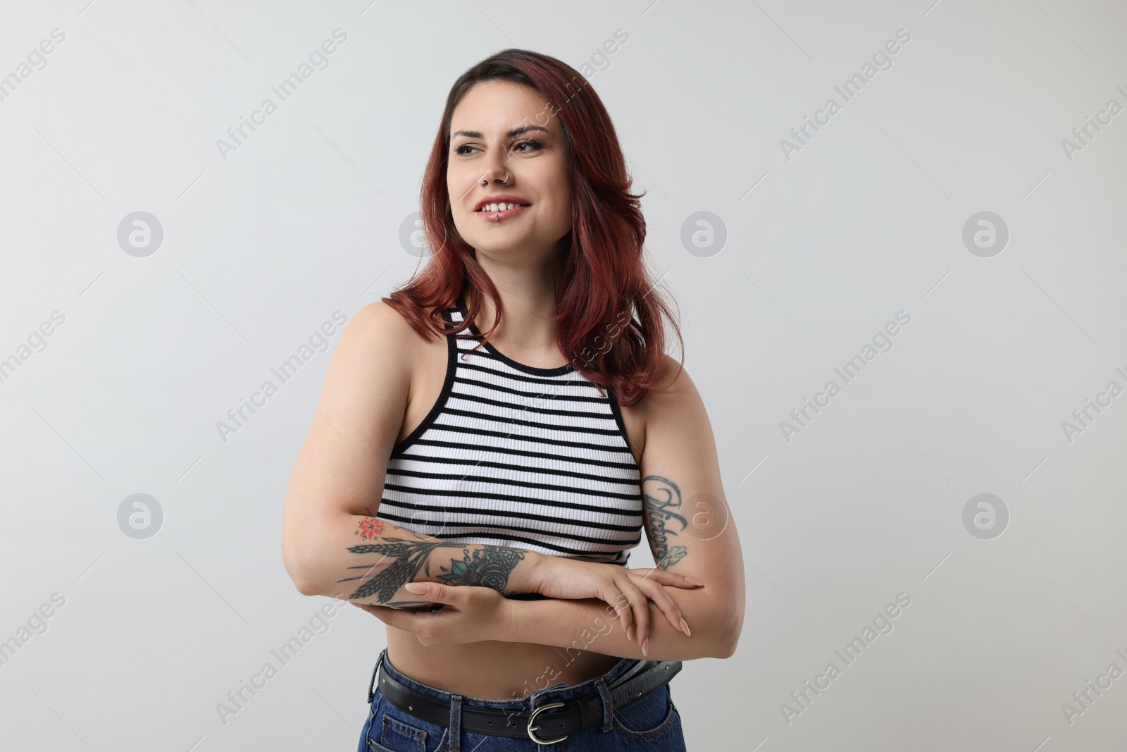 Photo of Portrait of beautiful tattooed woman on gray background