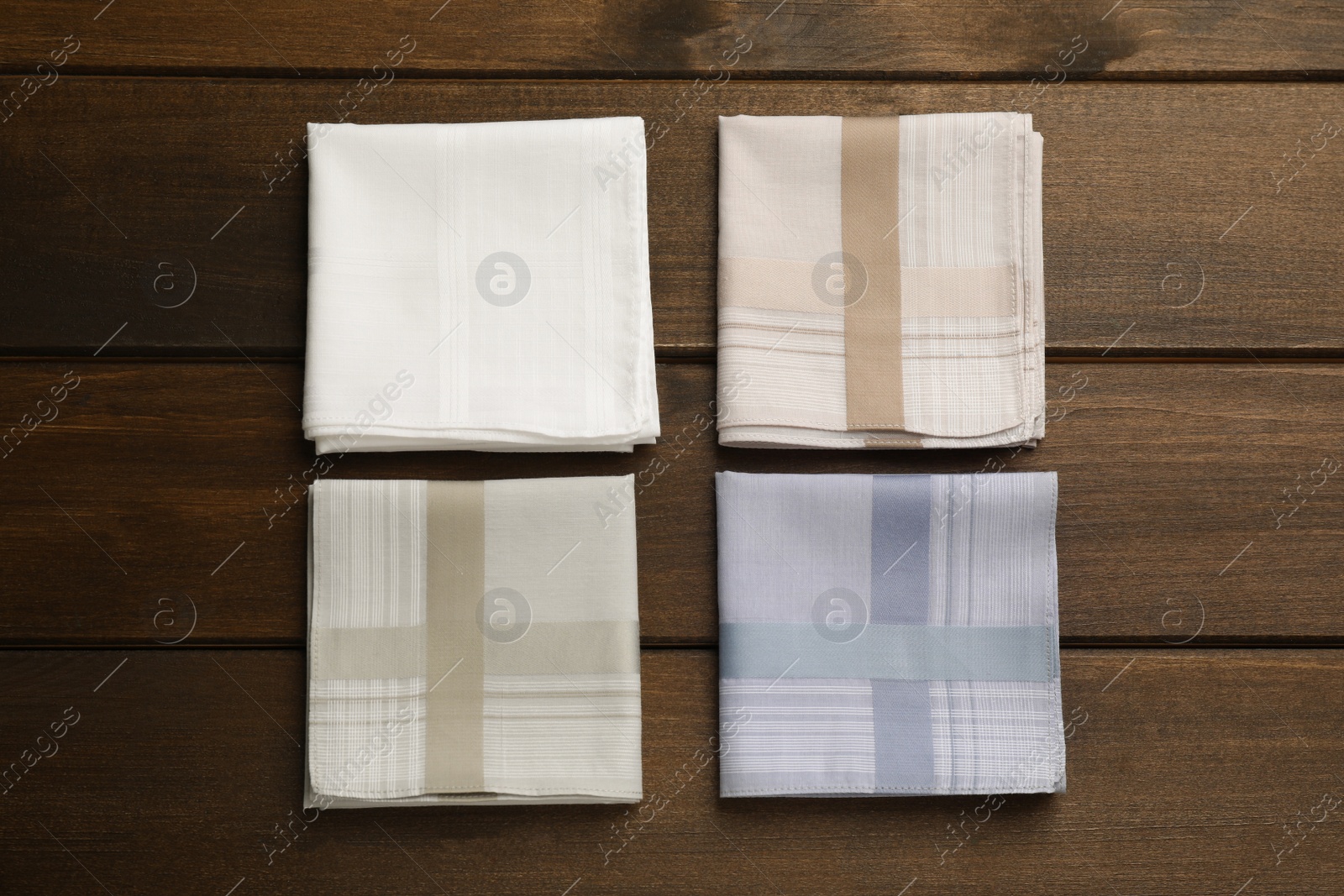 Photo of Different handkerchiefs folded on wooden table, flat lay