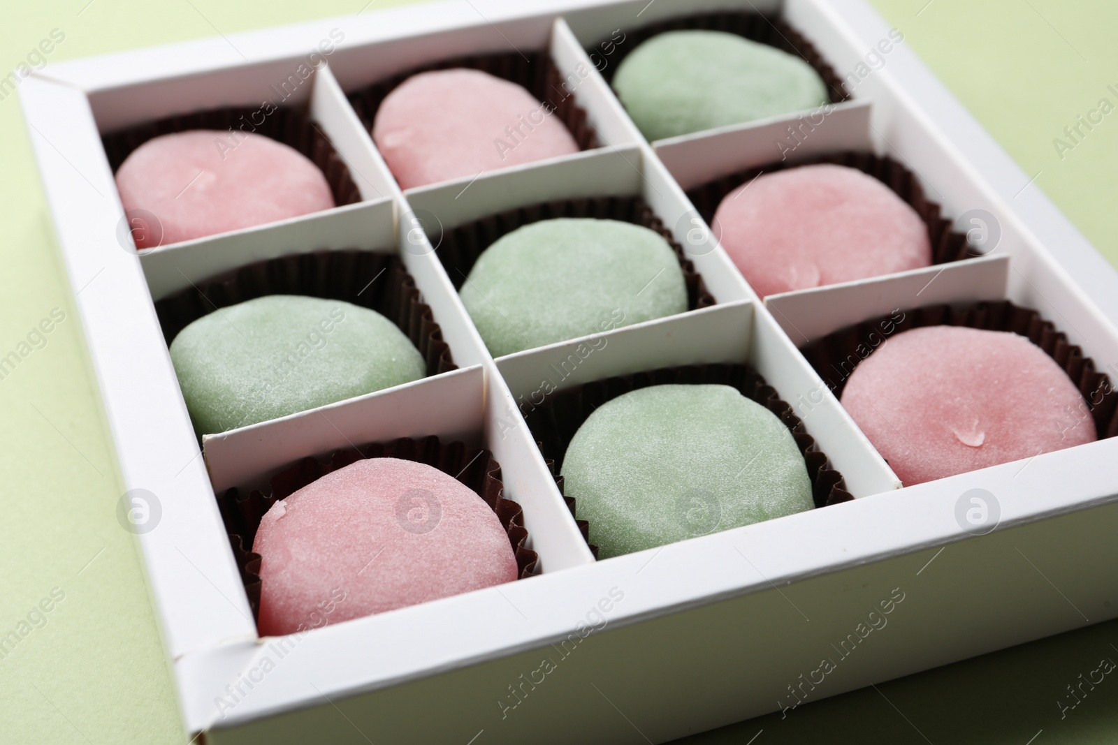 Photo of Many different delicious mochi in box on light background, closeup. Traditional Japanese dessert