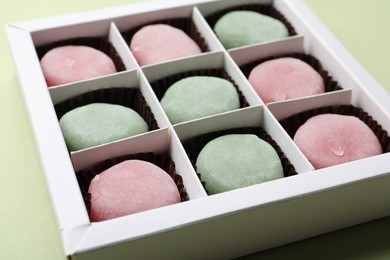 Many different delicious mochi in box on light background, closeup. Traditional Japanese dessert