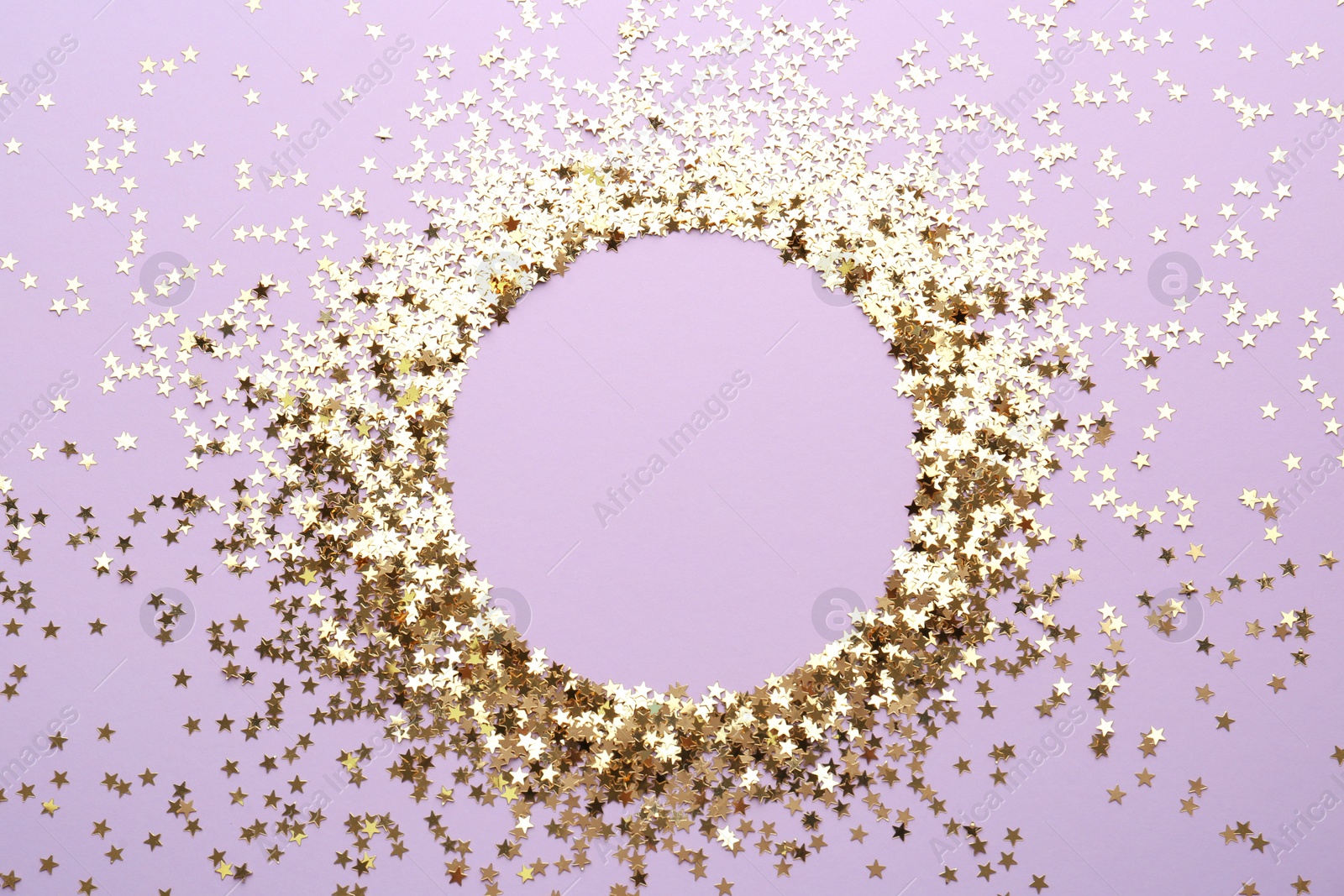 Photo of Frame of confetti stars on violet background, flat lay with space for text. Christmas celebration