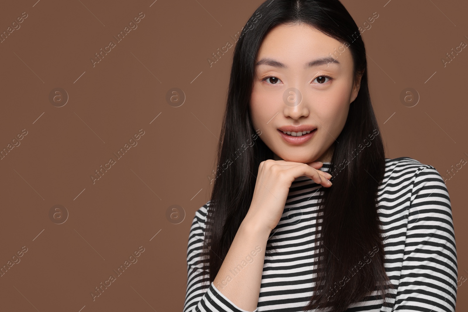 Photo of Portrait of smiling woman on brown background. Space for text