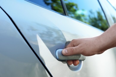 Closeup view of man opening car door