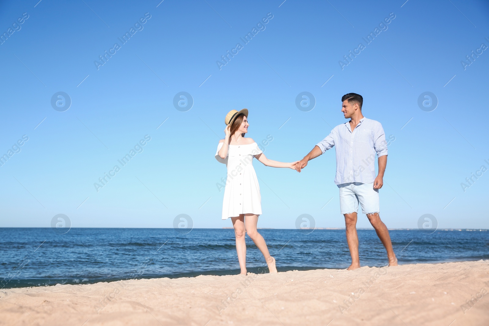 Photo of Lovely couple walking on beach. Space for text