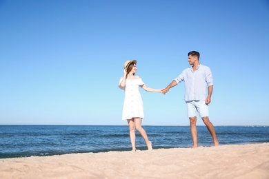 Lovely couple walking on beach. Space for text