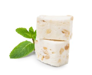 Photo of Pieces of delicious nougat and mint on white background