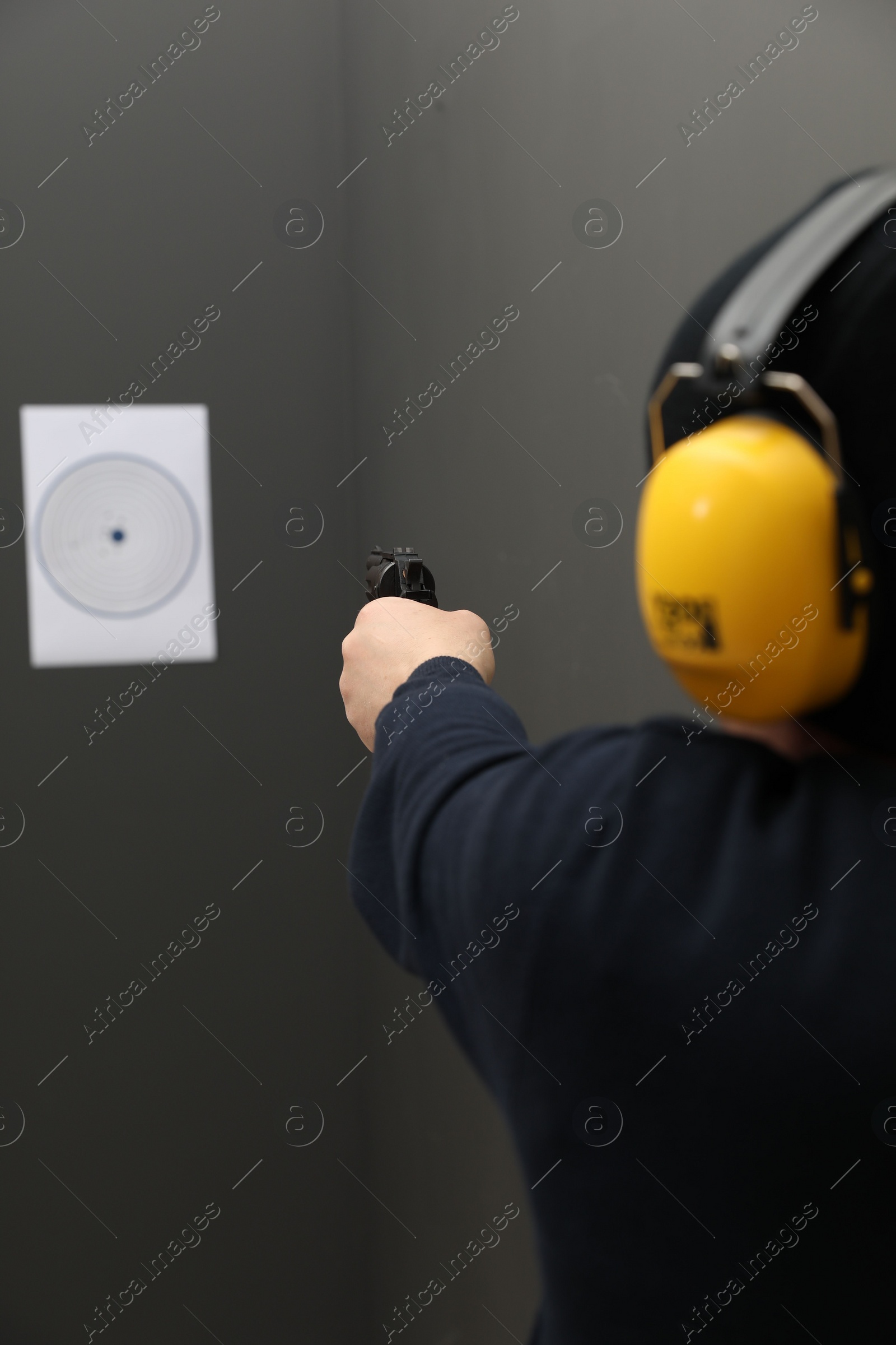 Photo of Man aiming at shooting target indoors, closeup