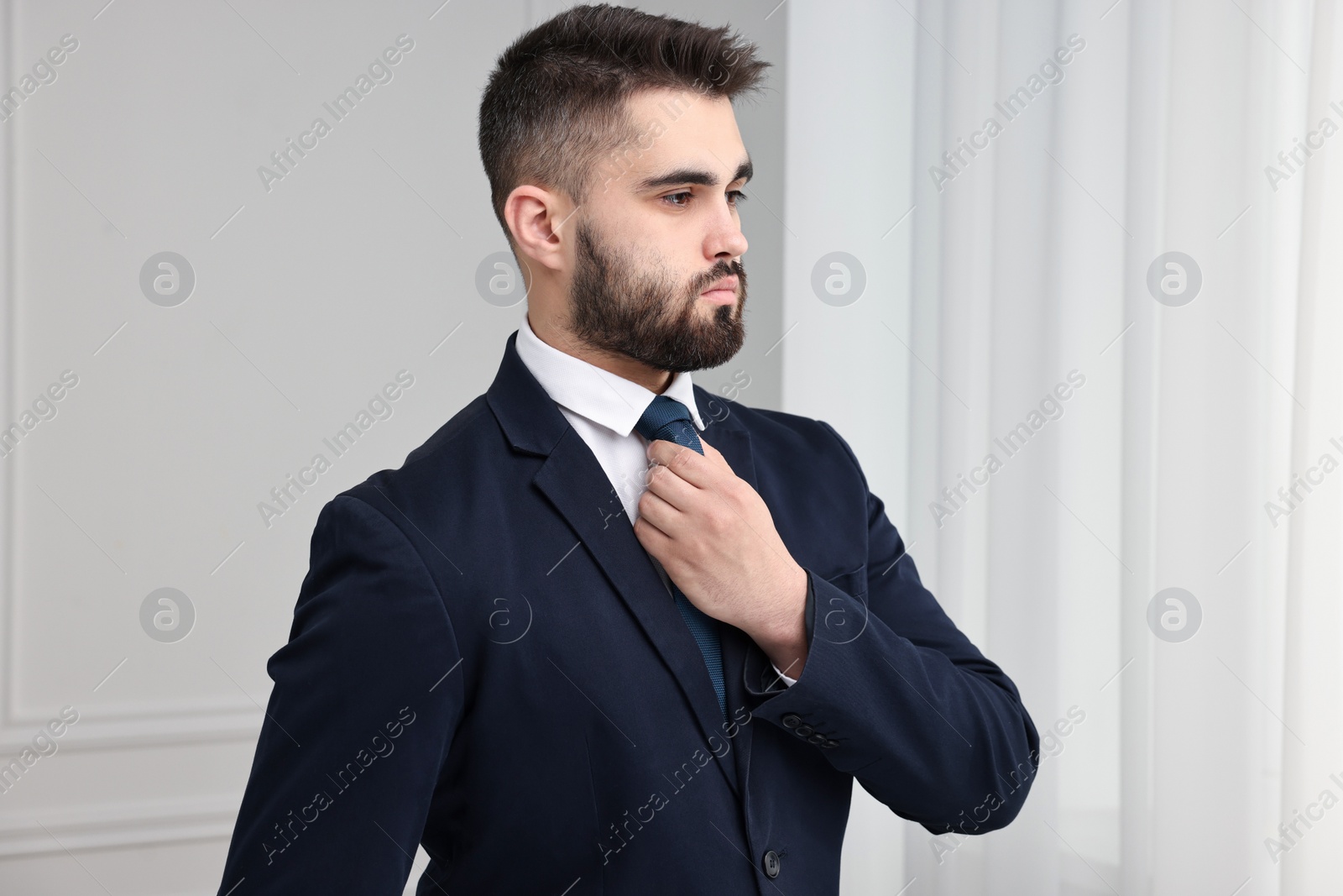 Photo of Handsome businessman in suit and necktie indoors