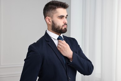 Handsome businessman in suit and necktie indoors