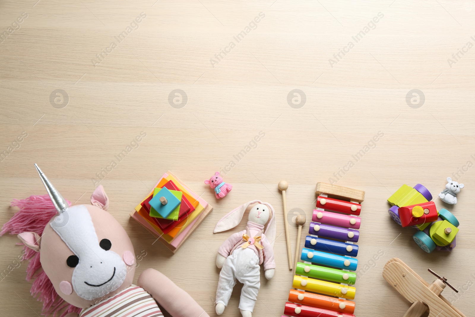 Photo of Different toys on wooden background, flat lay. Space for text