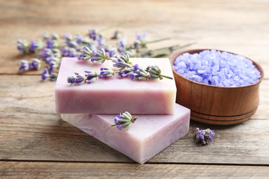 Photo of Composition with handmade soap bars and lavender flowers on brown wooden table, closeup