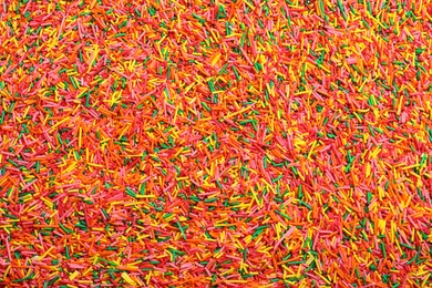 Bright colorful sprinkles as background, top view. Confectionery decor