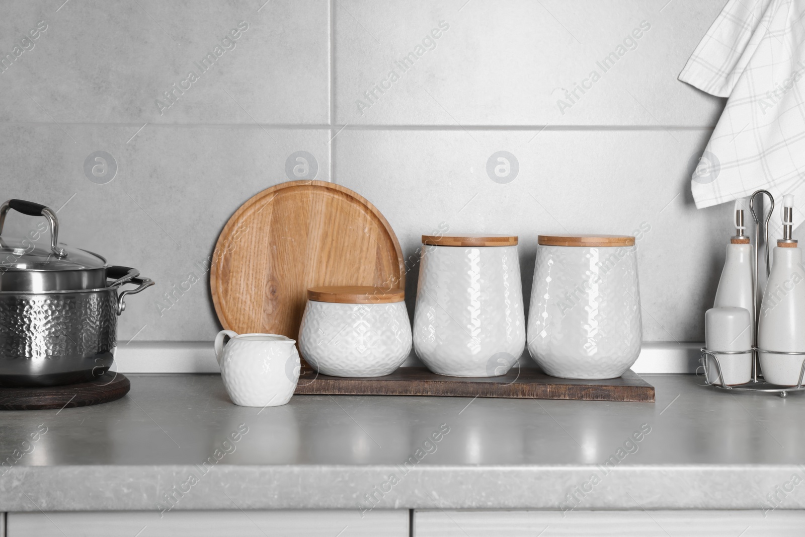 Photo of Different kitchenware and containers on grey countertop