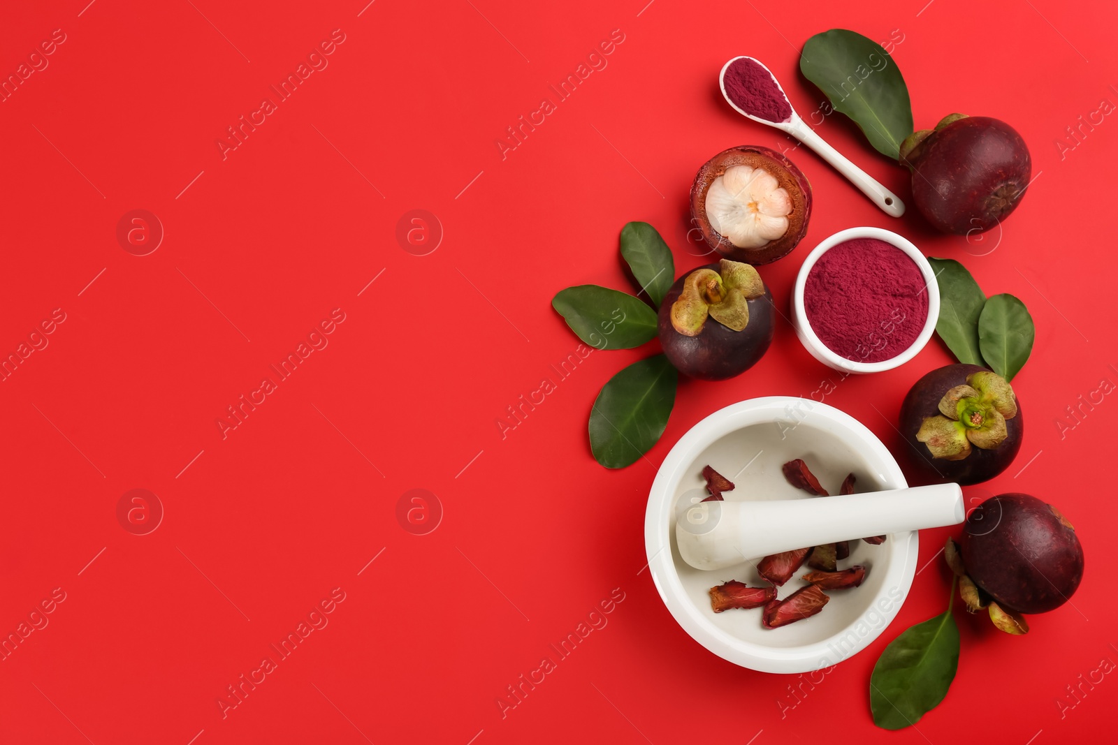 Photo of Purple mangosteen powder and fruits on red background, flat lay. Space for text