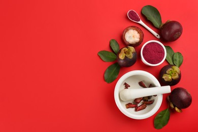 Purple mangosteen powder and fruits on red background, flat lay. Space for text