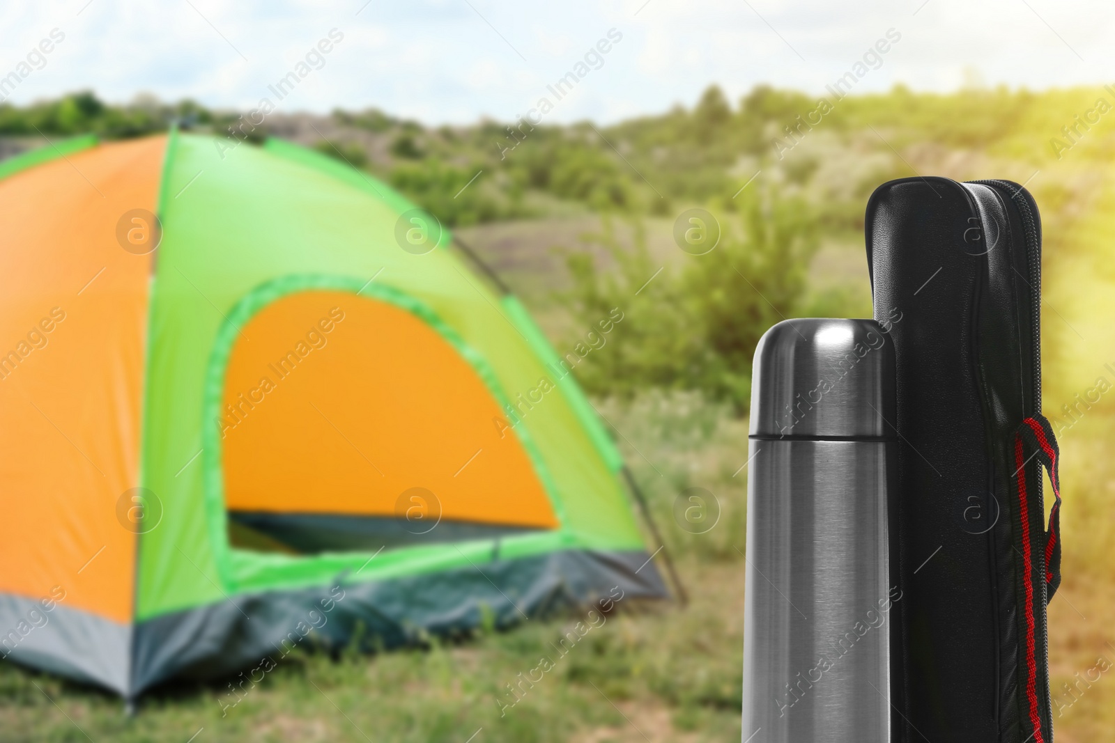 Image of Modern thermos and case outdoors, space for text. Camping season 