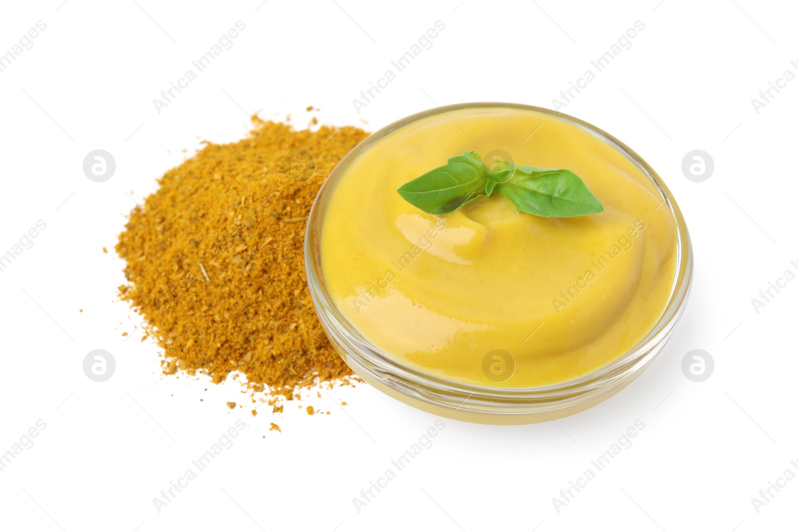 Photo of Bowl with tasty curry sauce, powder and basil isolated on white