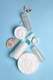Photo of Flat lay composition with different cosmetic products on light blue background