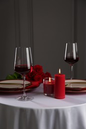 Photo of Place setting with candles and roses on white table. Romantic dinner