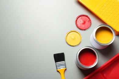 Photo of Flat lay composition with paint cans and brush on grey background. Space for text